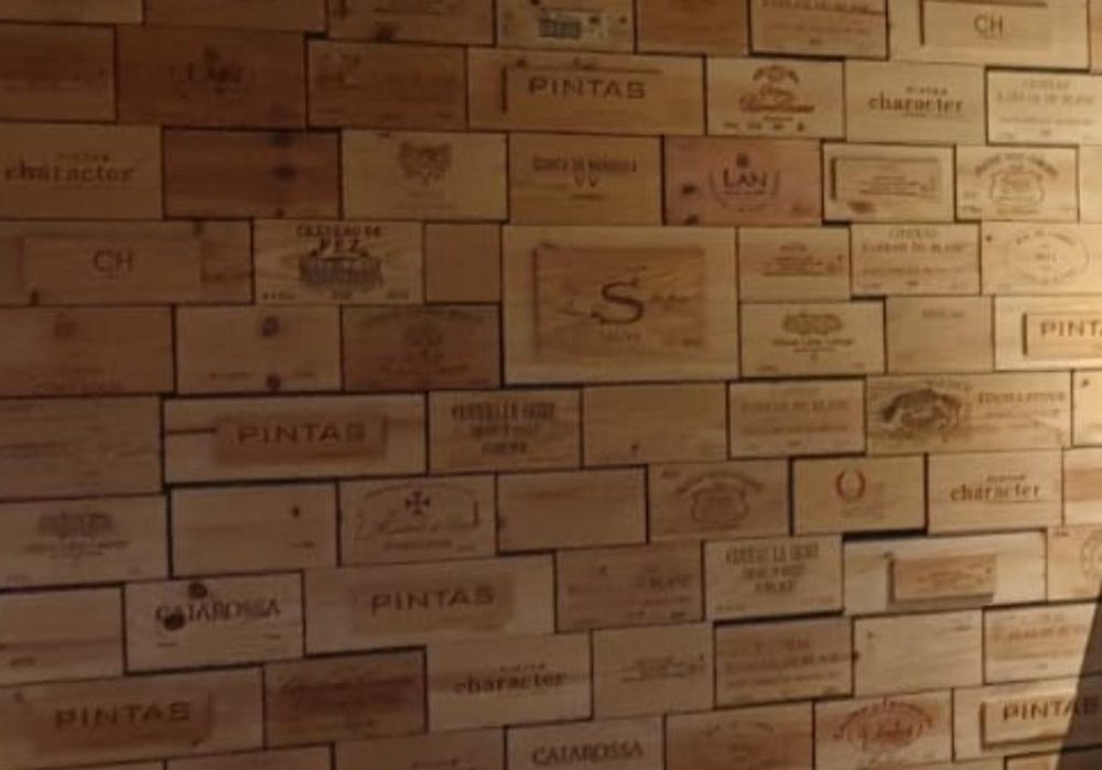 A wall built from stamped wooden wine-case end panels